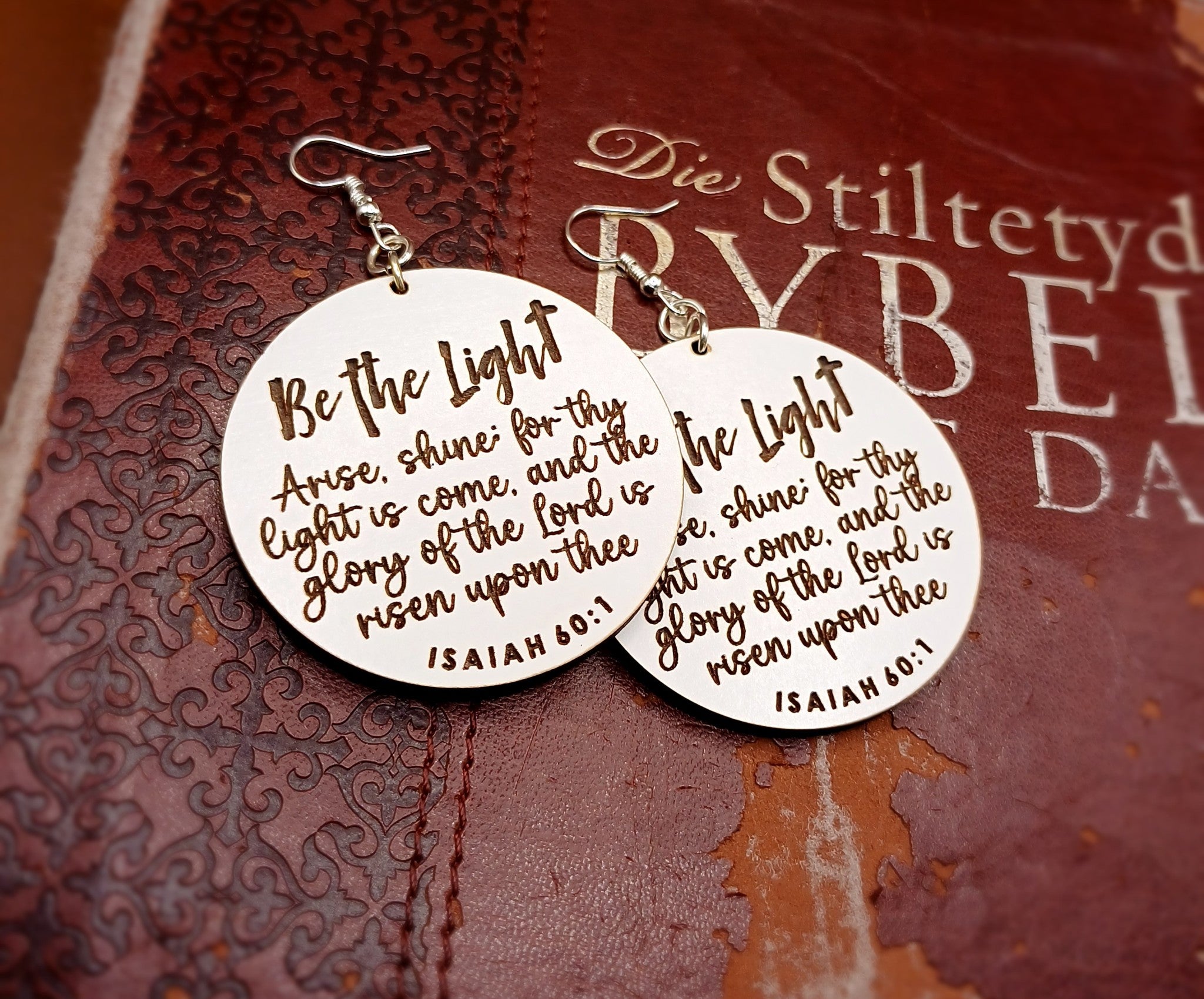 Be The Light Earrings displayed on the Bible